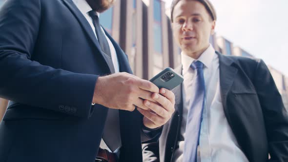 Confident businessman and his colleague in front of modern office building.