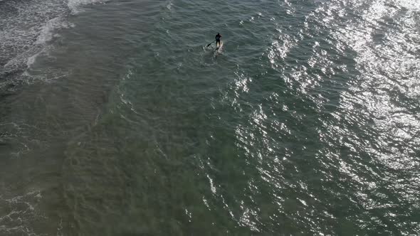 Man on Stand up paddle board surfing. Paddling on the quiet sea. long shot with a drone