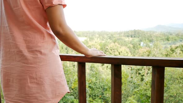 Woman walking to balcony, slowmotion in steadicam shot