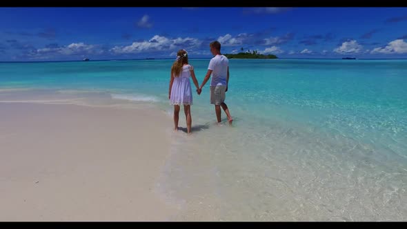Young couple engaged on tranquil coast beach lifestyle by blue lagoon with clean sandy background of
