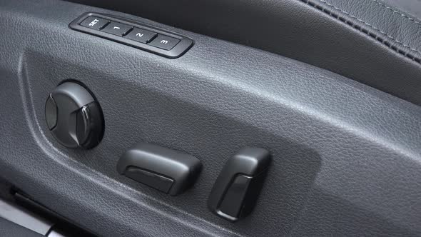 A Close Up View of Electric Seat Adjustment with Controlling Buttons, Inside a Car.