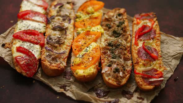 Assortment of Various Toppings Baked Sandwiches. With Melted Cheese, Vegetables, Tuna, Olives Spices