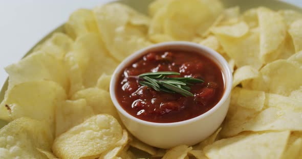 Video of crisps and salsa dip on a grey surface