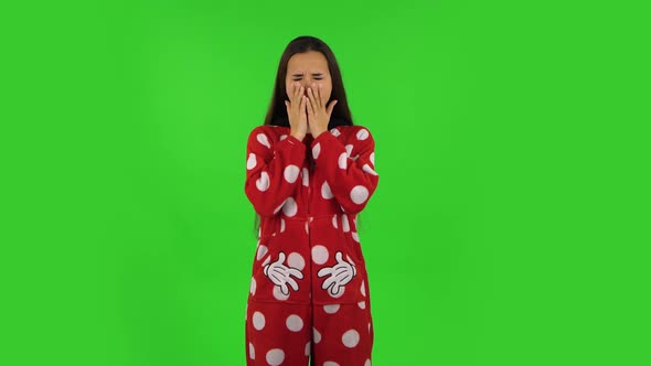Beautiful Girl in Red Fleece Pajamas Is Yawning, Bedtime Concept. Green Screen