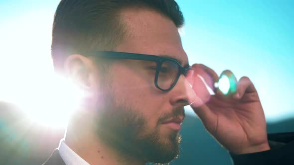 Successful businessman with glasses and a beard looks thoughtfully