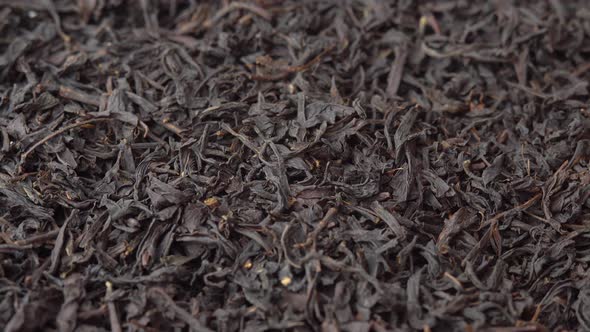 Black Loose Leaf Tea Spinning Close Up on Plate Tea Advertising Background for a Cafe or Restaurant