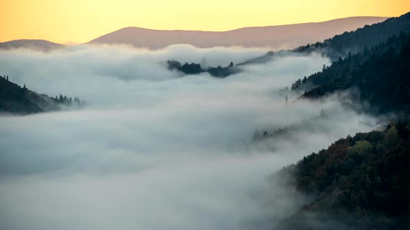 Beautiful Sunrise in Foggy Mountains. Timelapse of Running Mist in Green Mountains Early in the