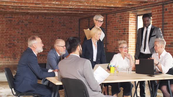 Group of Business People Brainstorming Together in Meeting Room