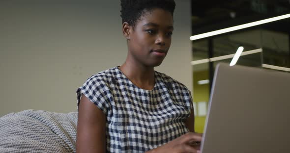 African american businesswoman sitting at desk using laptop in office