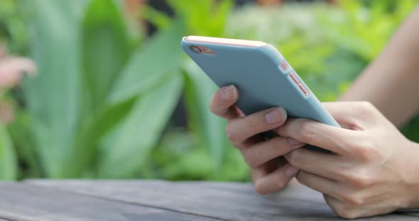 Woman Using Cellphone at Outdoor Cafe 