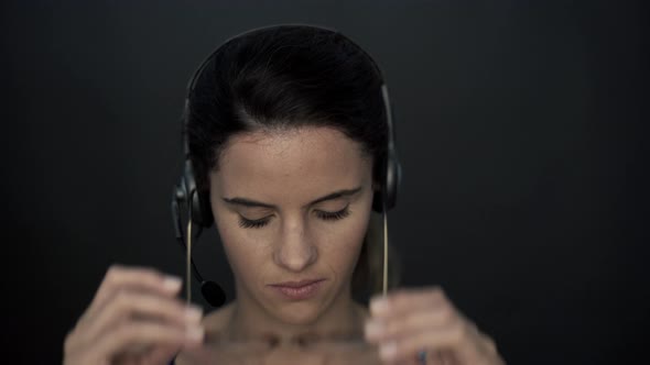 Woman removing glasses and headset and then smiling cheerfully at camera