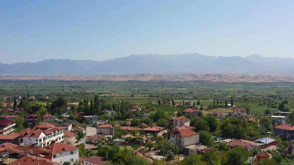 wide aerial view of a valley in southern Turkey with large mountains in the distance and a small vil