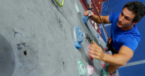 Man and woman practicing rock climbing in fitness studio 4k