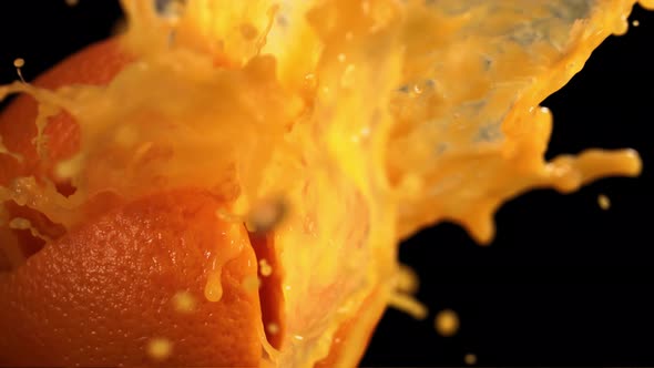 Fresh Orange Fruit Squirting with Juice in Slow Motion in Black Background