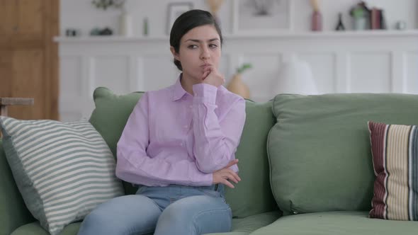 Indian Woman Thinking while Sitting on Sofa