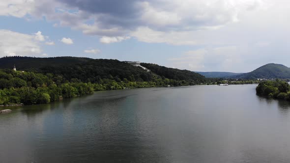 Aerial flyover above Danube River with view of Walhalla memorial on the hill, Zoom in