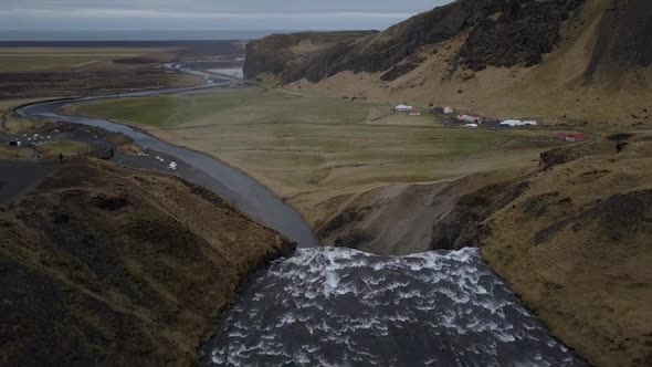 Aerial waterfall and green fields in Iceland
