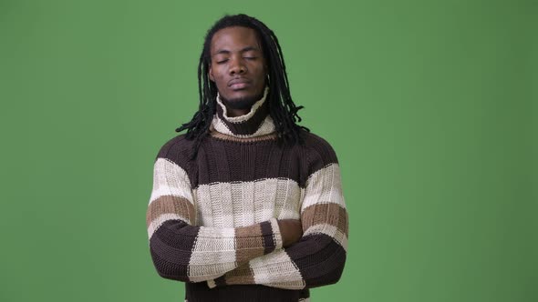 Young Handsome African Man with Dreadlocks Against Green Background