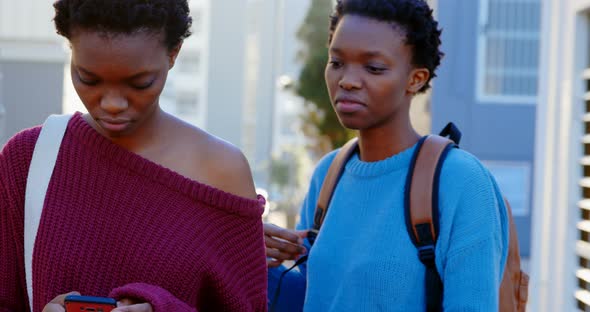 Twin sisters standing together in the city 4k