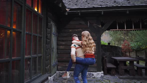 Love story. Dating outside. Young сouple on wooden house in forest background. 