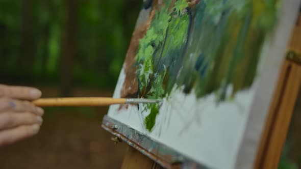 Woman's Hand Makes a Few Strokes on the Landscape Drawing on Tripod