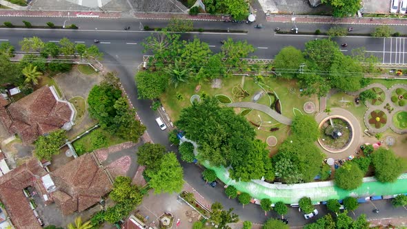 Top down view of vibrant city park with street traffic, aerial drone view