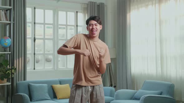 Asian Man Dancing While Shooting Video Content For Social Networks At Home