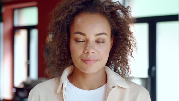 Headshot Portrait of Young Mixed Raced Woman Looking at Camera Indoors