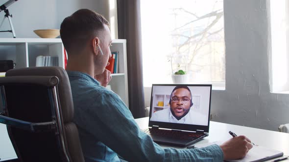 Young male entrepreneur works at home office at the computer.