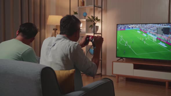 Cheerful Young Friends With Joystick Game Play Soccer Video Game On Tv And Celebrating Victory