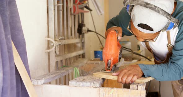 Surfboard maker using machine on wooden plank 4k