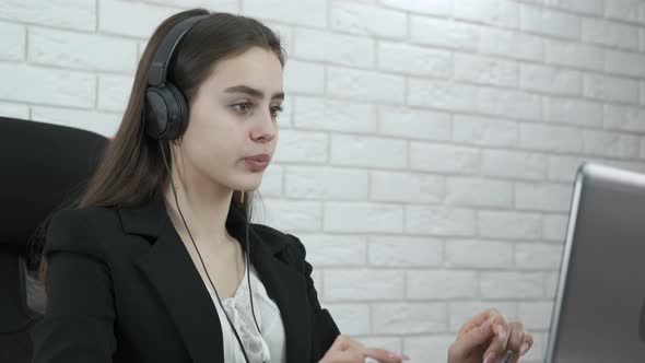 Office worker with headphones at the computer. 