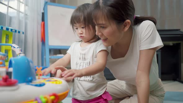 Asian happy family, beautiful mother and little girl kid playing toy together in living room at home