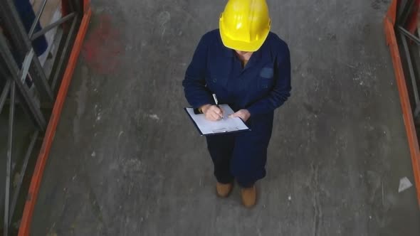 Female Inspector Walking through Warehouse