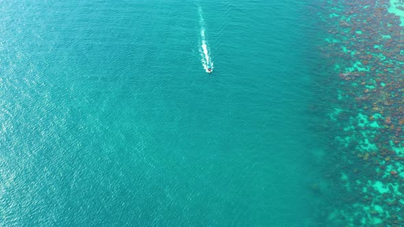 Aerial view of Long Tail Boats floating on crystal water along the sand beach in Thailand.Summer Aer
