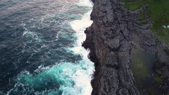 Aerial view of water encountering agitated Atlantic ocean, Faroe island.