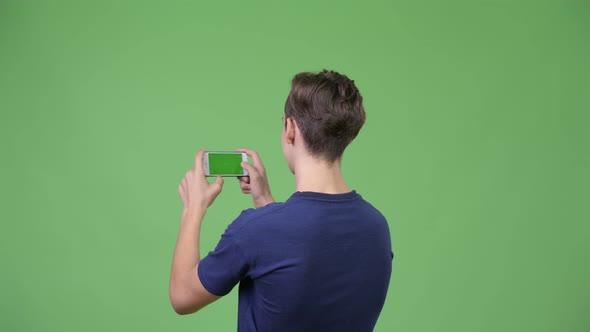 Young Handsome Teenage Boy Photographing with Phone