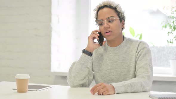 African Woman Talking on Smartphone in Office