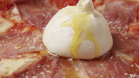 Rotating Prosciutto Pizza with Cheese on White Background