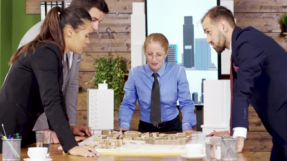 Businessman in Suit in the Conference Room Talking with Team of Architects