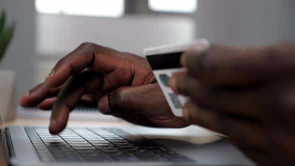 Hands African American Man Pressed Credit Card Code to Pay Online Via Laptop