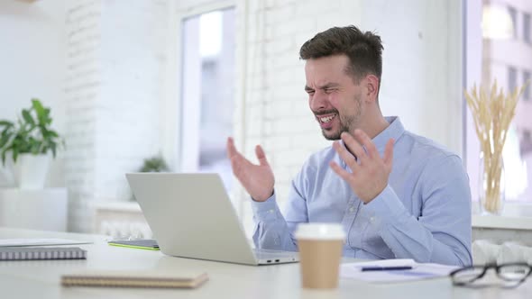 Shocked Man Reacting To Loss on Desktop, Astonished