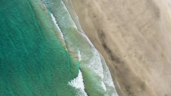 Aerial view on the Lofoten beach with splashing sea waves