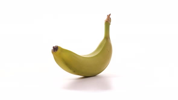 One Fresh Yellow Banana is Spinning on White Background