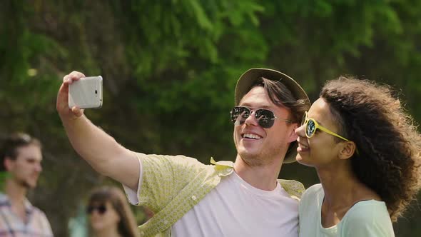 Young People Using Gadget to Take Selfie, Looking Through Pictures and Laughing