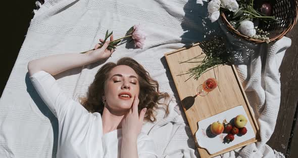 Young Woman Relaxing at Picnic with Closed Eyes Feeling Pleasure