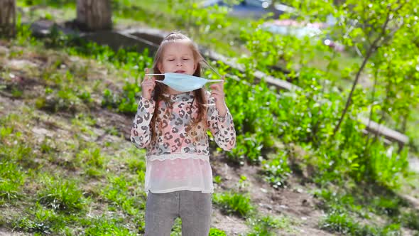 Happy  the little girl takes off a medical mask and the joyful runs.