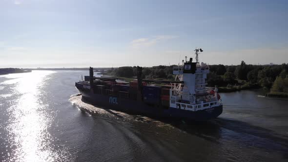 NCL Alesund Cargo Container Ship Travelling By The River With Loaded Intermodal Containers. wide sho