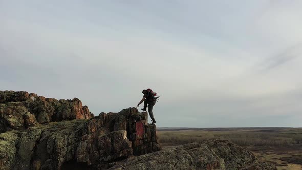 A Man Climbing to the Top of a Mountain