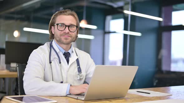 Happy Doctor Smiling and Looking at Camera in Clinic